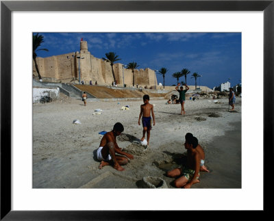 Children Playing On Beach In Front Of Restored Fort Ribat, Monastir, Tunisia by Damien Simonis Pricing Limited Edition Print image
