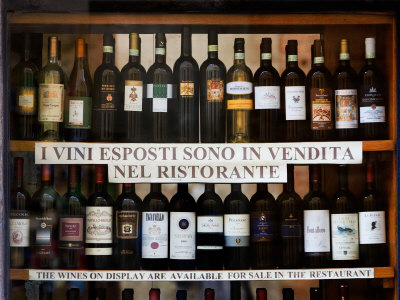 Wine Bottles In Restaurant Window, San Gimignano, Italy by Robert Eighmie Pricing Limited Edition Print image