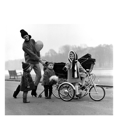 Jenny Boyd In Light Pants And Boots With Children, 1960S by John French Pricing Limited Edition Print image