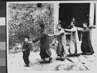 Barefoot Boy Leading Chain Of Blind Men, Through Street During Famine by George Silk Pricing Limited Edition Print image