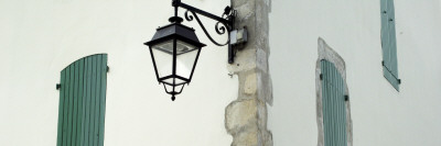 Streetlamp On A Building With Shuttered Windows, Il De Re, France, by Olwen Croft Pricing Limited Edition Print image