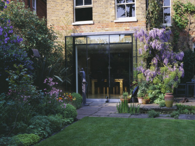 View Of Lawn And Back Of House With Rectangular Pool, Wisteria, Glass Fronted Kitchen And Sculpture by Clive Nichols Pricing Limited Edition Print image