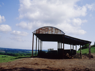 Semi-Derelict Corrugated Iron Barn Silhouetted Against View Of Countryside, Rusting, Somerset by Philippa Lewis Pricing Limited Edition Print image