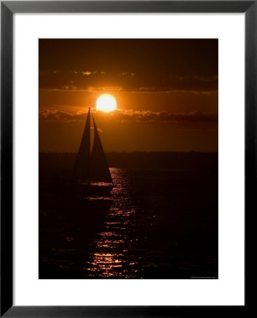 Lone Sailboat Silhouetted By The Setting Sun by Todd Gipstein Pricing Limited Edition Print image