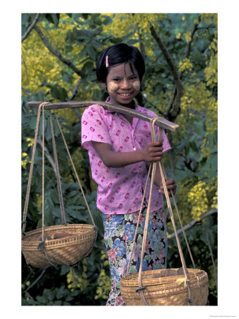 Girl With Painted Face Carrying Basket On Shoulder Pole, Myanmar by Keren Su Pricing Limited Edition Print image