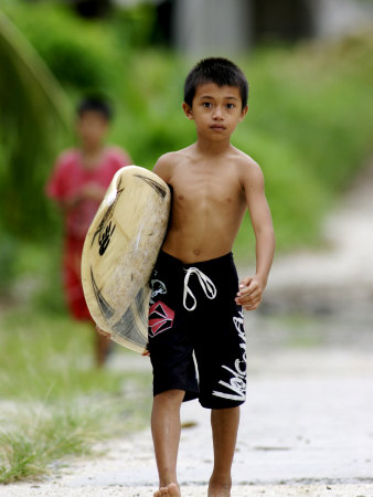 Young Local Boy Heading Out For Afternoon Surf, Lagundri Bay, Pulau Nias, North Sumatra, Indonesia by Paul Kennedy Pricing Limited Edition Print image