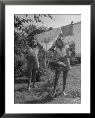 Teenage Twin Girls Hanging Laundry On Clothesline by Nina Leen Pricing Limited Edition Print image