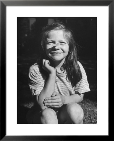 Young Girl With Long Hair And Raggedy Shirt, Smiling, Wearing Seed Pod On Nose by Ralph Morse Pricing Limited Edition Print image