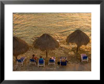 Guests Relax At Sunset Along The Water At The Caribe Blu Hotel, Cozumel, Mexico by Michael S. Lewis Pricing Limited Edition Print image