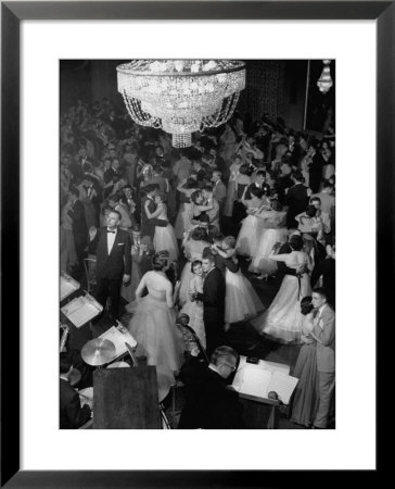Young Couples At Formal Dance Dreamily Swaying On Crowded Floor Of Dim, Chandelier-Lit Ballroom by Nina Leen Pricing Limited Edition Print image