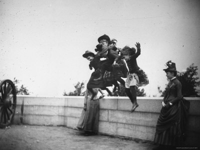 Four Young Girls Jumping Off A Waist High Wall As Two Women Look On At Ft. Greene by Wallace G. Levison Pricing Limited Edition Print image