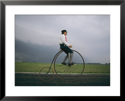 A Man Pedals An Old-Fashioned Bicycle Ahead Of An Indiana Thunderstorm by Melissa Farlow Pricing Limited Edition Print image