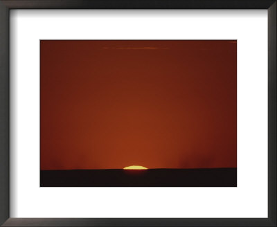 A Contrast Shot Of Red Sky And Dark Horizon, With A Setting Sun by Kenneth Garrett Pricing Limited Edition Print image