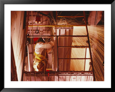 Sparks Fly From A Welders Torch As He Works From A Scaffold by Joel Sartore Pricing Limited Edition Print image