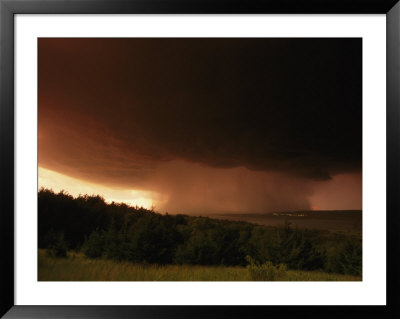 A Dark Cloud With Heavy Rain Moves Towards A Small Lighted Town by Peter Carsten Pricing Limited Edition Print image