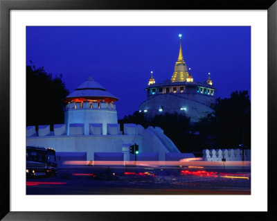 Illuminated Golden Mount At Wat Saket And Democracy Monument Bangkok, Thailand by Tom Cockrem Pricing Limited Edition Print image