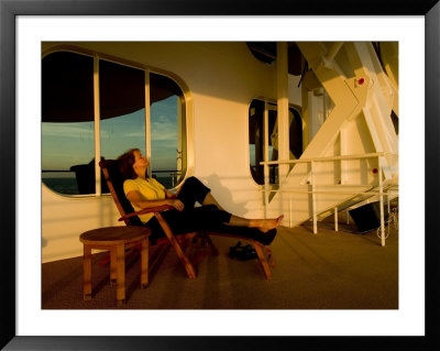 Woman Sitting On A Deck Chair Of A Cruise Ship Watching The Sunset by Todd Gipstein Pricing Limited Edition Print image