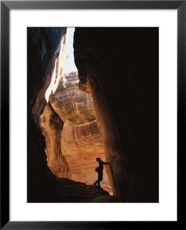 A Man Explores A Cave In Chelser Canyon by Rich Reid Pricing Limited Edition Print image