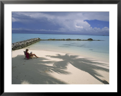 Woman Reads In Solitude On A Quiet Beach Next To Turquoise Water by James L. Stanfield Pricing Limited Edition Print image