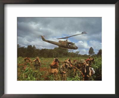 American Uh1 Huey Helicopter Lifting Off As Personnel On The Ground Protect Themselves by Larry Burrows Pricing Limited Edition Print image