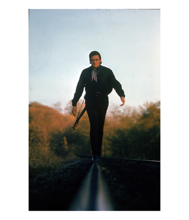 Country Music Star Johnny Cash Walking Along Line Of Railway Track With His Guitar by Michael Rougier Pricing Limited Edition Print image