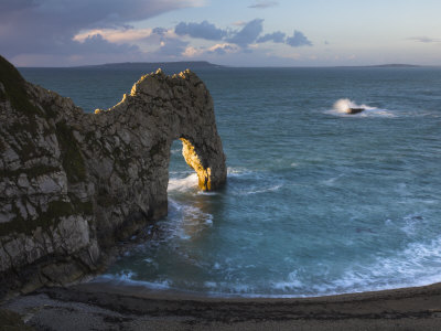 Archway Of Durdle Door Glowing Golden In Early Morning Sunlight, Jurassic Coast, Dorset, England by Adam Burton Pricing Limited Edition Print image