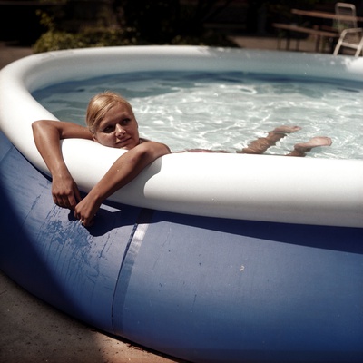 A Young Woman Relaxing In An Inflatable Swimming Pool by Jewgeni Roppel Pricing Limited Edition Print image
