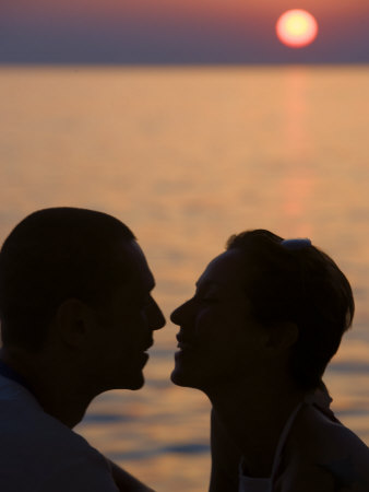 Silhouette Of Two People About To Kiss At Sunset by Scott Stulberg Pricing Limited Edition Print image