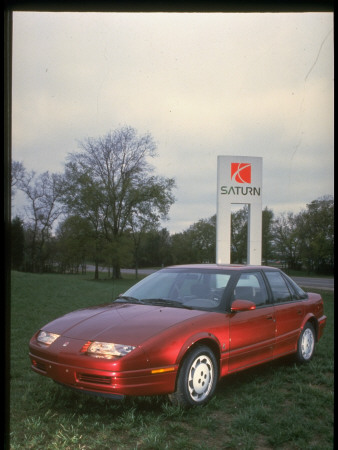 Spiffy Spanking New Red Saturn Sl2 Sports Touring Sedan On Logo Sign, Gm Plant In Spring Hill by Ted Thai Pricing Limited Edition Print image