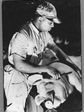 Knife-Wielding Butcher About To Cut Up Dead Pig At Swift Meat Packing Packington Plant by Margaret Bourke-White Pricing Limited Edition Print image