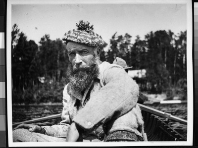 A Bearded Man Wearing A Scottish Tam And Rough Tweed Jacket While Sitting In A Row Boat by George B. Brainerd Pricing Limited Edition Print image