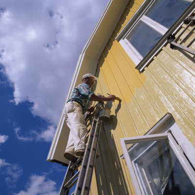 A Man Painting A Yellow House, Sweden by Ove Eriksson Pricing Limited Edition Print image
