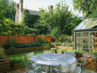 View Across Modernists Town Garden With Metal Garden Furniture And Conservatory In The Foreground by Clive Nichols Pricing Limited Edition Print image