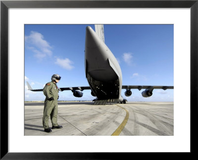 A Soldier Waits For His C-17 Globemaster Iii To Launch On An Upcoming Airdrop Mission by Stocktrek Images Pricing Limited Edition Print image