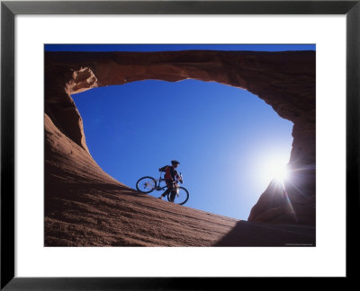 Mountain Biker Stands Under An Arch by Bill Hatcher Pricing Limited Edition Print image