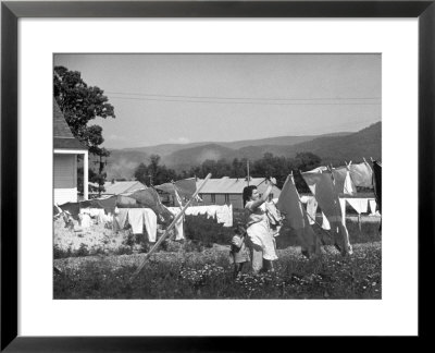Housewife In Tygart Valley Removing Laundry From Clothesline, Her Young Daughter Stands Beside Her by Carl Mydans Pricing Limited Edition Print image