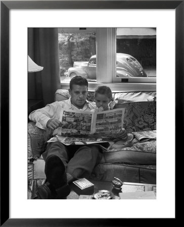 Father Sitting On Couch With Pigtailed Daughter Reading To Her The Sunday Comic Pages by Nina Leen Pricing Limited Edition Print image