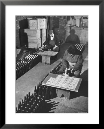 Men Putting Labels On Wine Bottles by Ralph Morse Pricing Limited Edition Print image