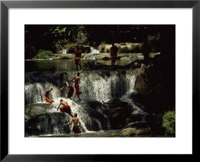 Gently Sloping Waterfalls Surrounded By Rich Vegetation In Which Eight Novice Monks Are Bathing by James L. Stanfield Pricing Limited Edition Print image