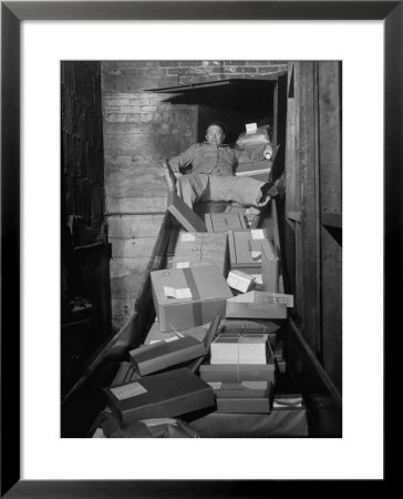 Macy's Department Store Employee Mike Reynolds Clearing The Package Chute With His Body by Nina Leen Pricing Limited Edition Print image