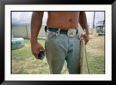 A Close View Of A Man In Jeans With A Large Belt Buckle Holding A Rope by Jodi Cobb Pricing Limited Edition Print image