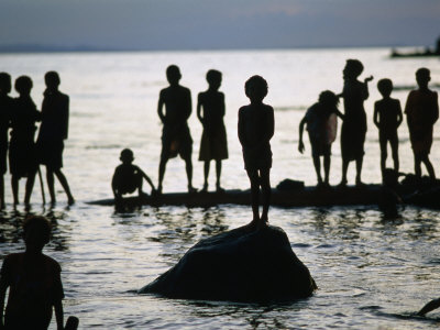 Playing Children Silhouetted Against Water, Malala, Papua New Guinea by Jerry Galea Pricing Limited Edition Print image