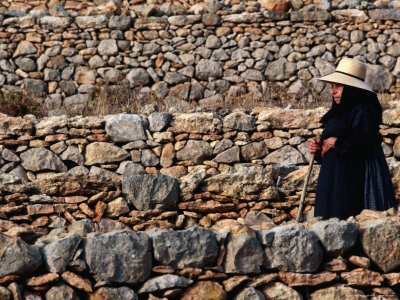 Local Walking Past Rows Of Stone Walls, Ibiza, Spain by Bill Wassman Pricing Limited Edition Print image