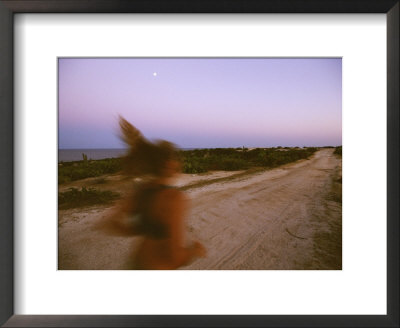 A Woman Runs Down A Dirt Road In Baja, Mexico At Sunset by Jimmy Chin Pricing Limited Edition Print image