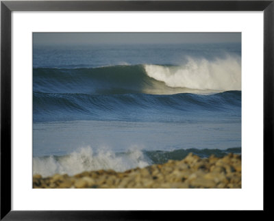 Large Waves Break And Rush To A Rocky Shore At Sunrise by Rich Reid Pricing Limited Edition Print image