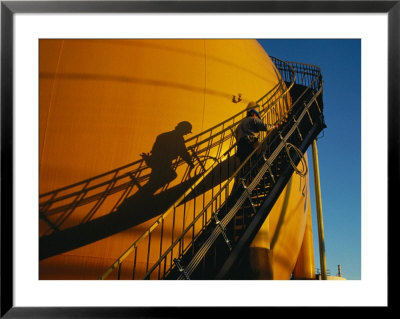 A Workman Climbs A Stairway On A Petroleum Storage Tank by Sisse Brimberg Pricing Limited Edition Print image