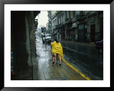Two People Share A Raincoat As They Hurry Down A Rainy Street by Pablo Corral Vega Pricing Limited Edition Print image