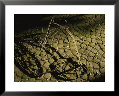 An Old-Fashioned Bicycle Lies On A Brick Patio by Tino Soriano Pricing Limited Edition Print image