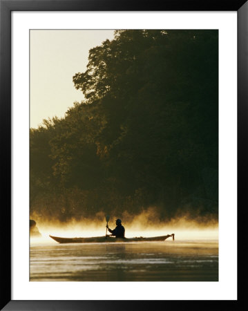 A Kayaker Paddles Through The Mist In The Low Sunlight by Skip Brown Pricing Limited Edition Print image