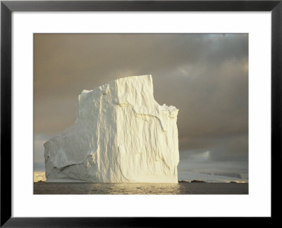 Twilight View Of A Large Iceberg Under A Cloudy Sky by Bill Curtsinger Pricing Limited Edition Print image
